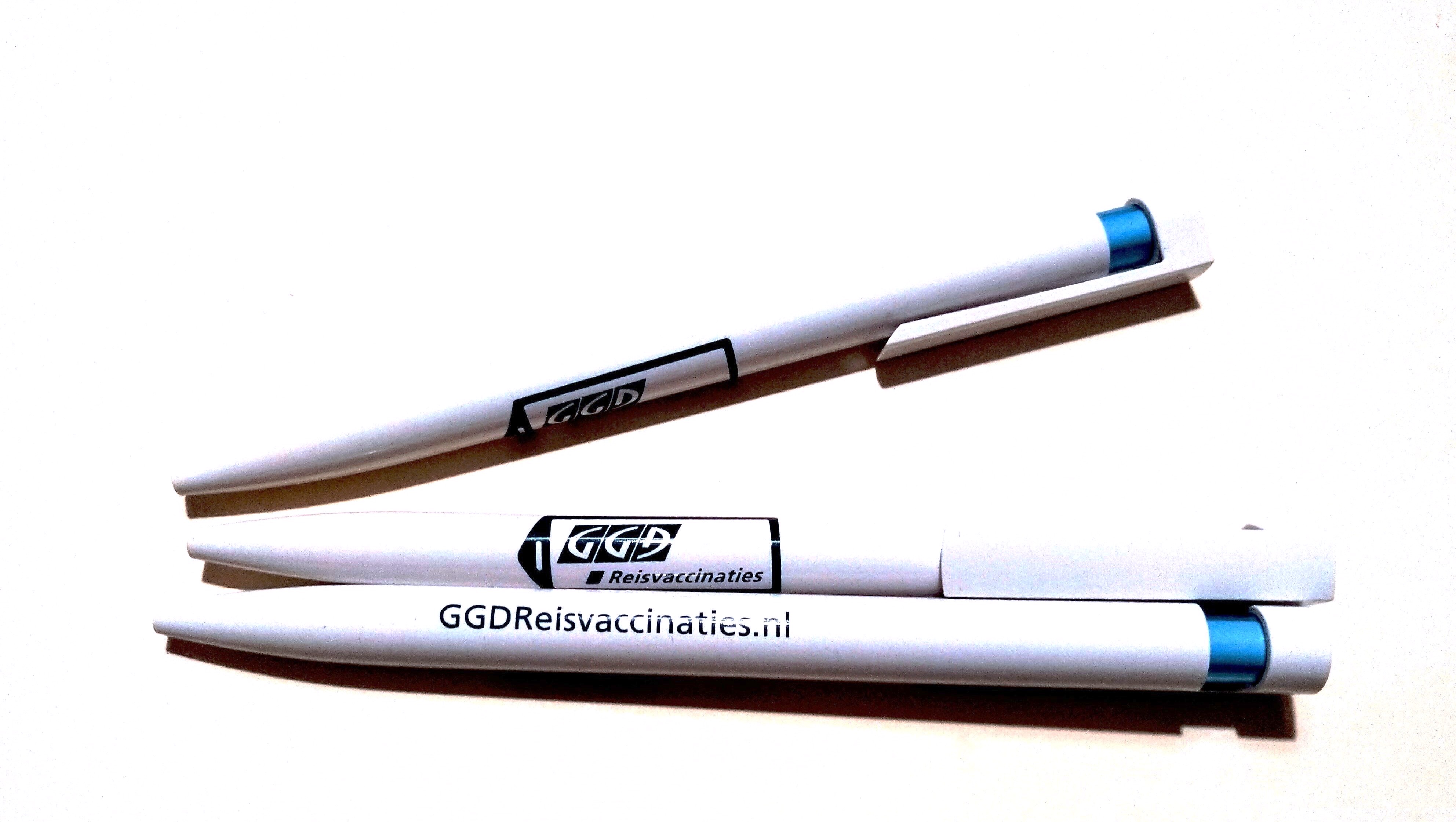 Witte balpen met in blauw het logo van GGDReisvaccinaties en ggdreisvaccinaties.nl