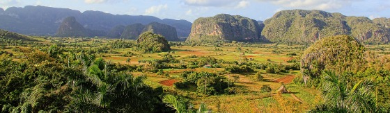 Foto van groen landschap met bergen in Cuba. De zon schijnt en blauwe lucht.
